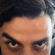Oscar Isaac stares you down intensely, in front of a backdrop of Marvel Comics Moon Knight art.